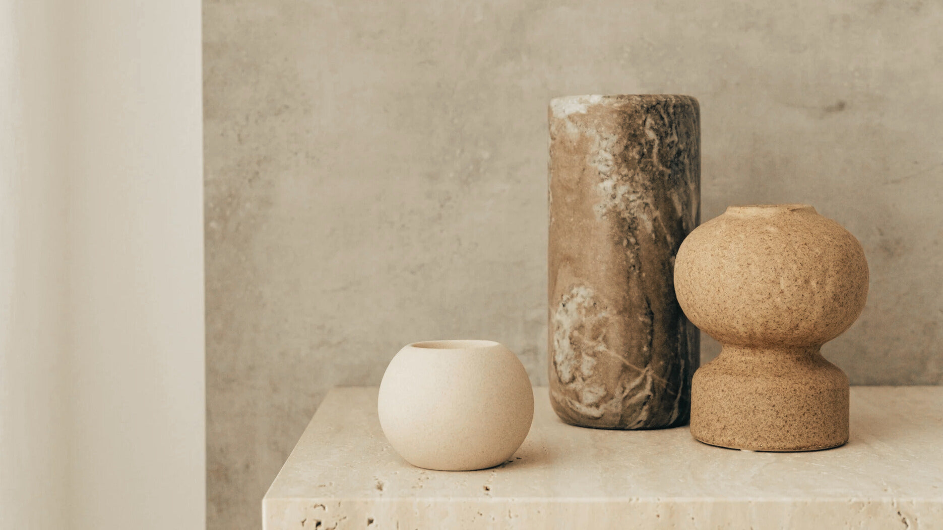 Bannière Clarahome - Objets de décoration en pierre et céramique sur une table en marbre, avec le slogan "Créer avec sens, transmettre avec amour